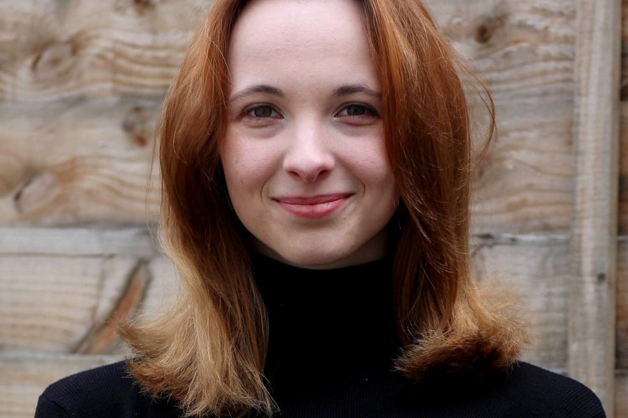 A photo of Kasia looking at the camera. She is wearing a black top and has auburn coloured hair.